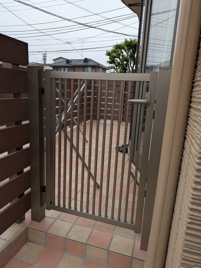 上尾市の外構施工事例｜縦格子の門扉の寄りで、奥にタイルテラスが見える
