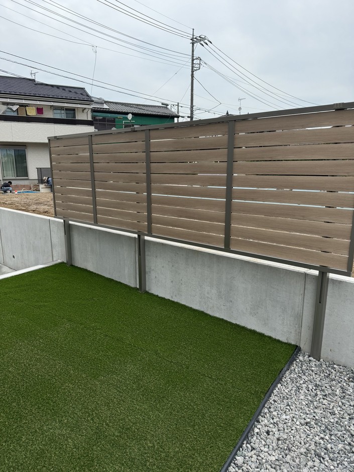 上尾市の外構施工事例｜人工芝の庭と木目調横板の目隠しフェンス