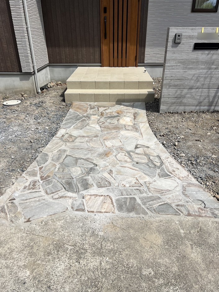 埼玉県朝霞市の施工事例｜乱形石と木調デッキに、もとからの景石が寄り添