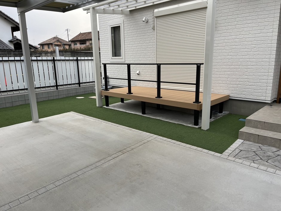 ふじみ野市の外構施工事例｜テラス屋根の下のウッドデッキと黒手すり・人工芝
