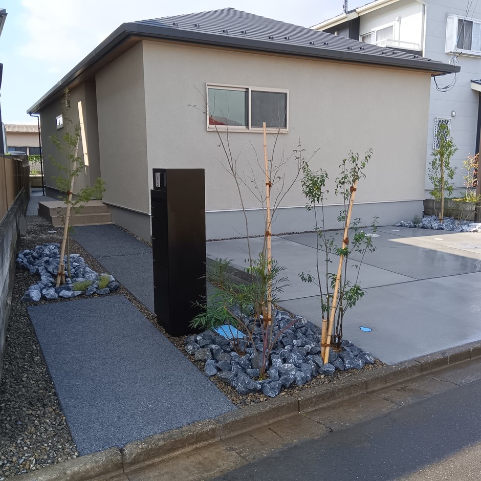 川越市の新築外構で植栽と割栗石が高低差を受けるアプローチ