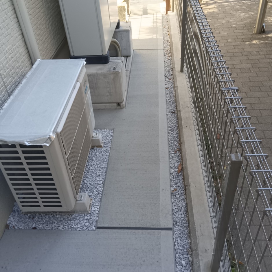 新座市の外構施工事例｜犬走りの土間コンクリートと白砕石の見切り帯、設備まわりの砕石納まり